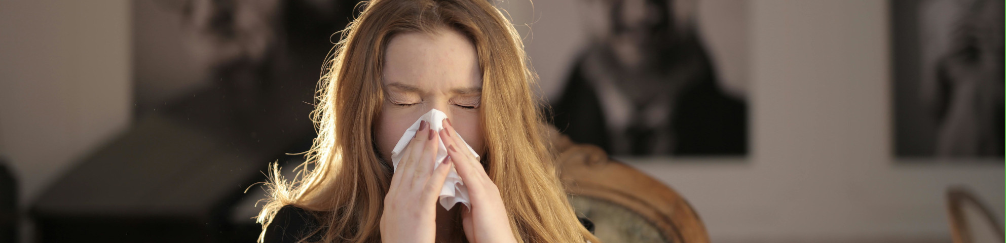 Eine Frau nutzt ein Taschentuch um ihre Nase zu putzen